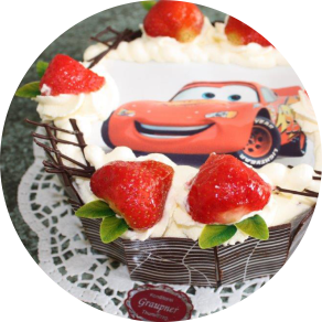 Beispielbild einer Schulanfangstorte mit Cars als Motivbild und frischen Erdbeeren. Der Link auf dem Bild führt zur Produktübersicht unserer Tauftorten